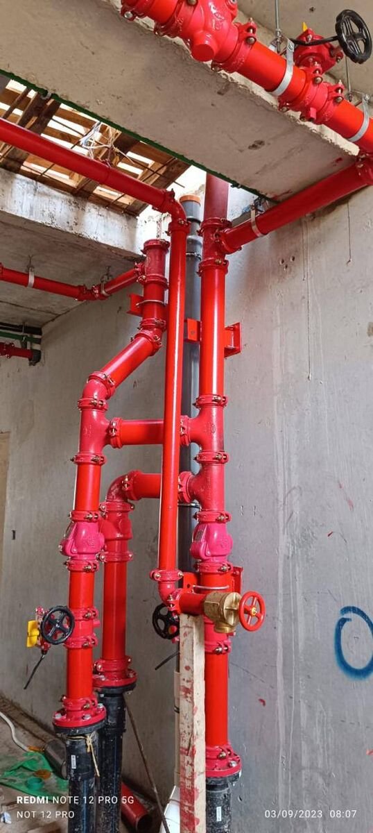 Riser shaft — fire main and service risers on anchors and guides.