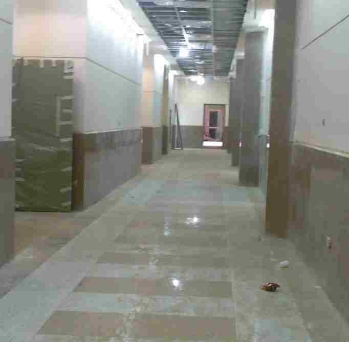 Corridor floor and wall base in matched stone.