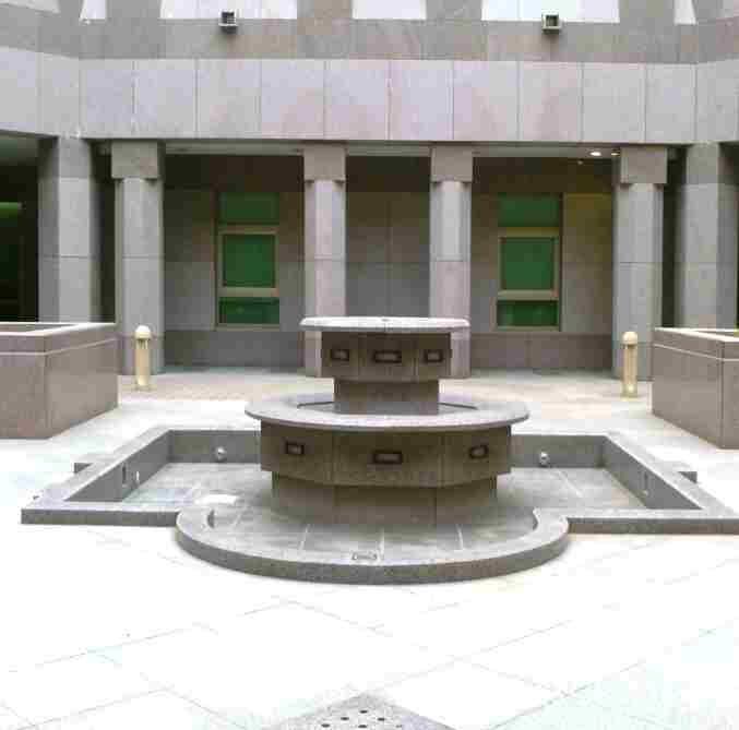 Courtyard fountain and colonnade in dressed stone.