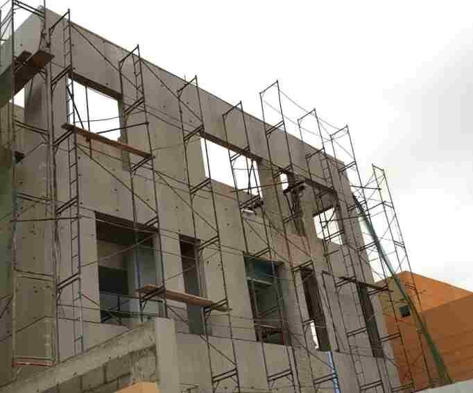 External facade works in progress on a concrete frame.