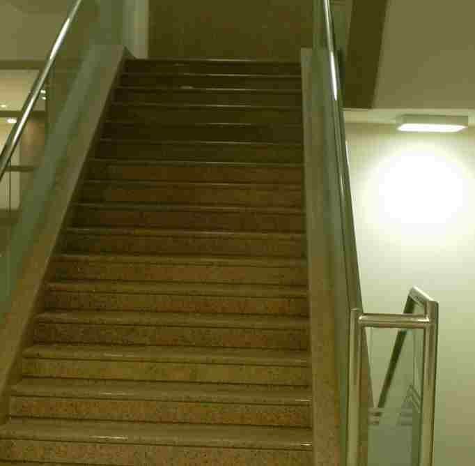 Granite stair flight with stainless handrail.
