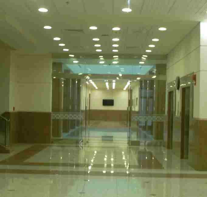 Lobby circulation — glazed screens and ceiling lighting.